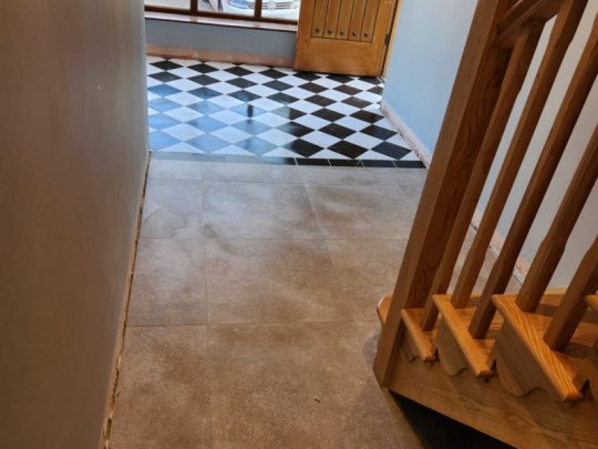 Wood-effect porcelain floor tiles installed in a Dublin home entrance hallway with staircase and patterned tiled porch area.