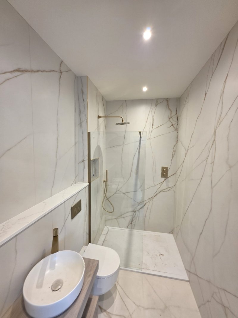 Minimalist marble bathroom with gold fixtures and vessel sink by RC Tiling Dublin