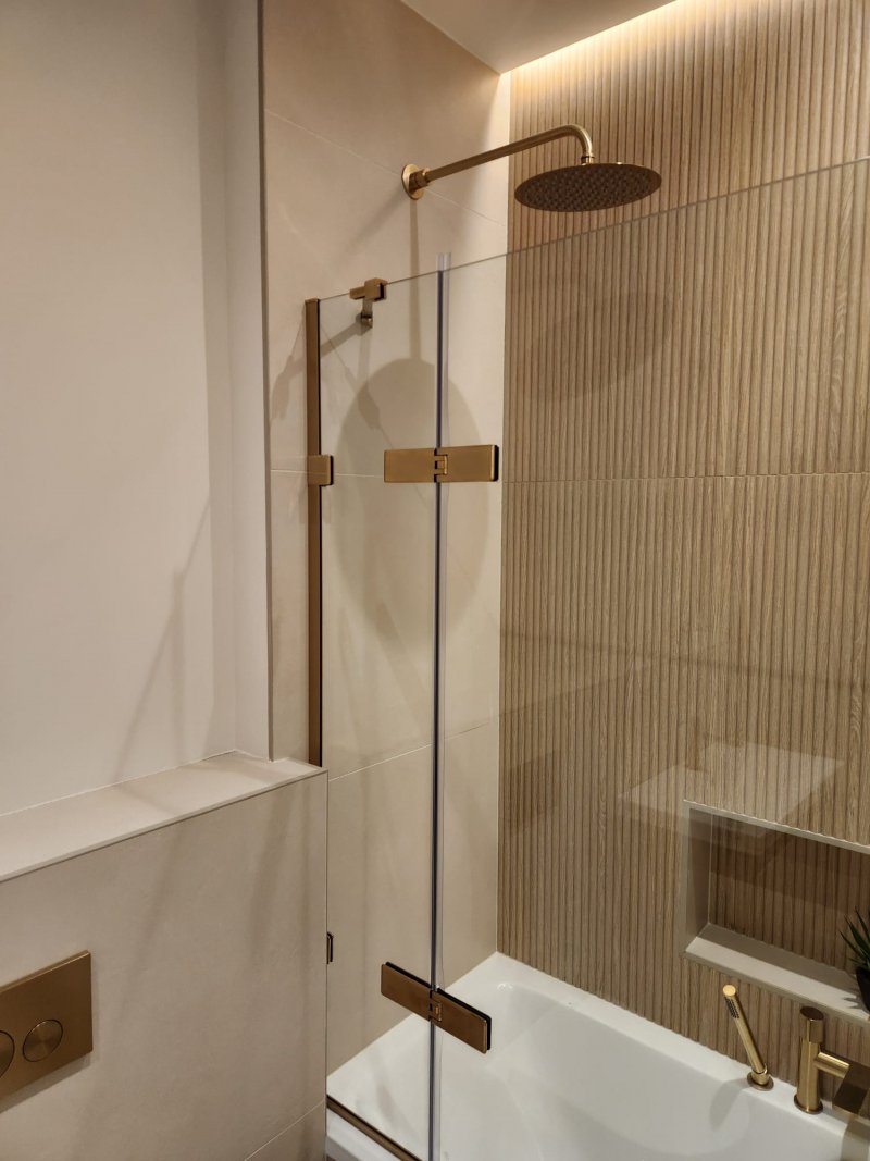 Minimalist bathroom with wooden vanity and gold fixtures by RC Tiling Dublin