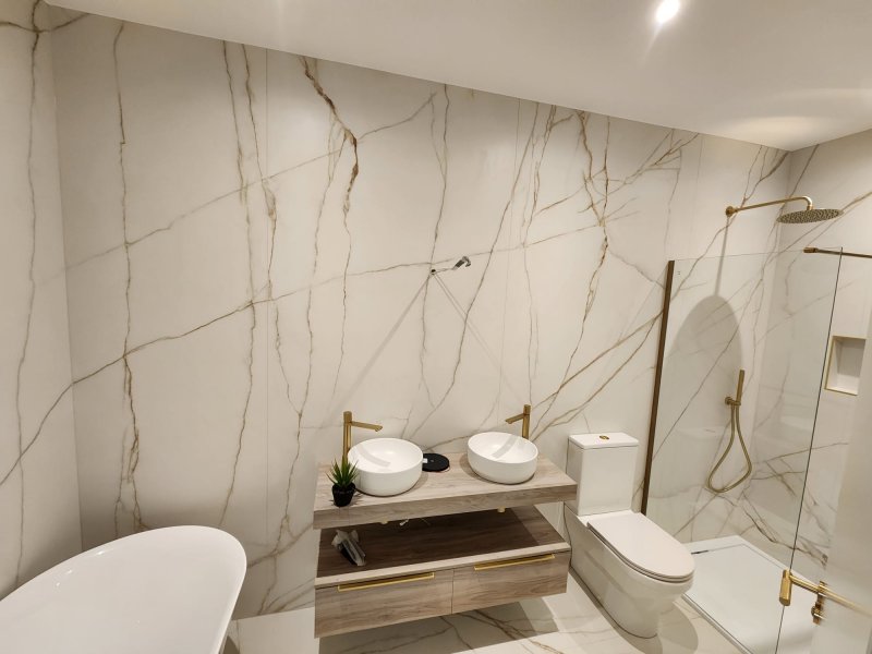 Modern marble bathroom with double vanity and gold fixtures