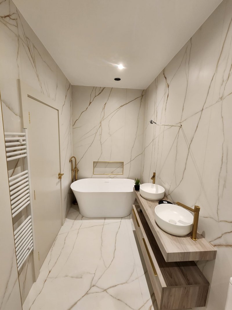 Luxury bathroom tiling Dublin marble effect porcelain tiles gold fixtures freestanding bath.