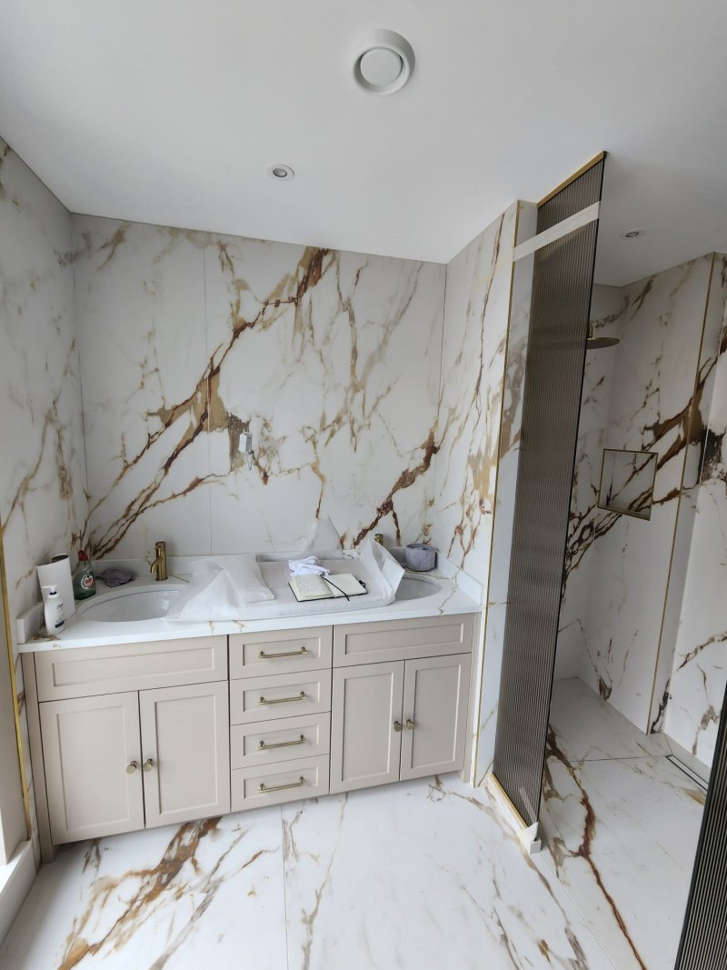 Marble bathroom renovation with recessed shelving and partition wall by RC Tiling Dublin