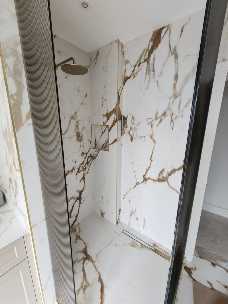 Premium marble shower with gold rainfall and handheld fixtures by RC Tiling Dublin
