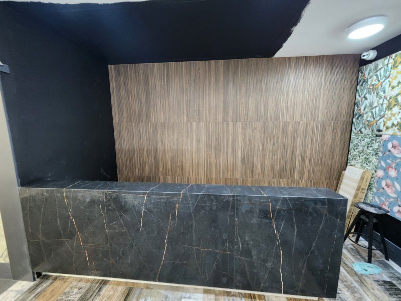 Wide view of black marble reception desk with gold veining – RC Tiling Dublin