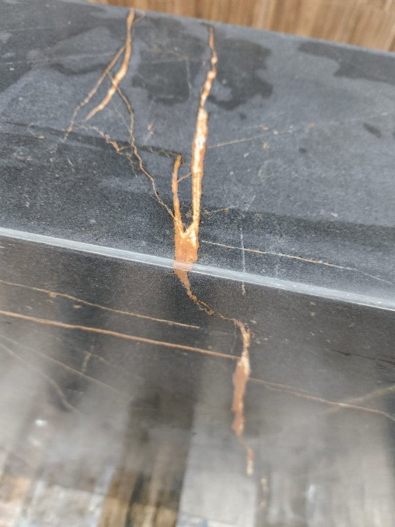 Corner joint detail of black marble with aligned gold veining – RC Tiling Dublin