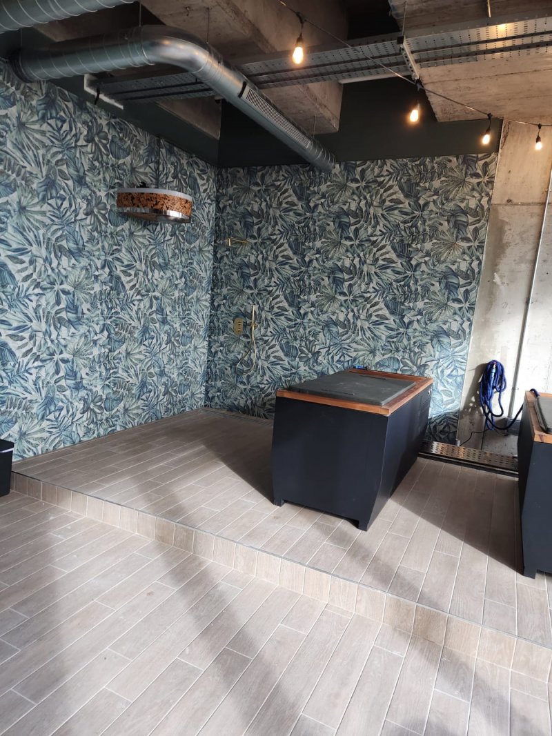 Modern wet room with light wood-effect herringbone floor tiles and steps, installed by RCTiling Dublin.