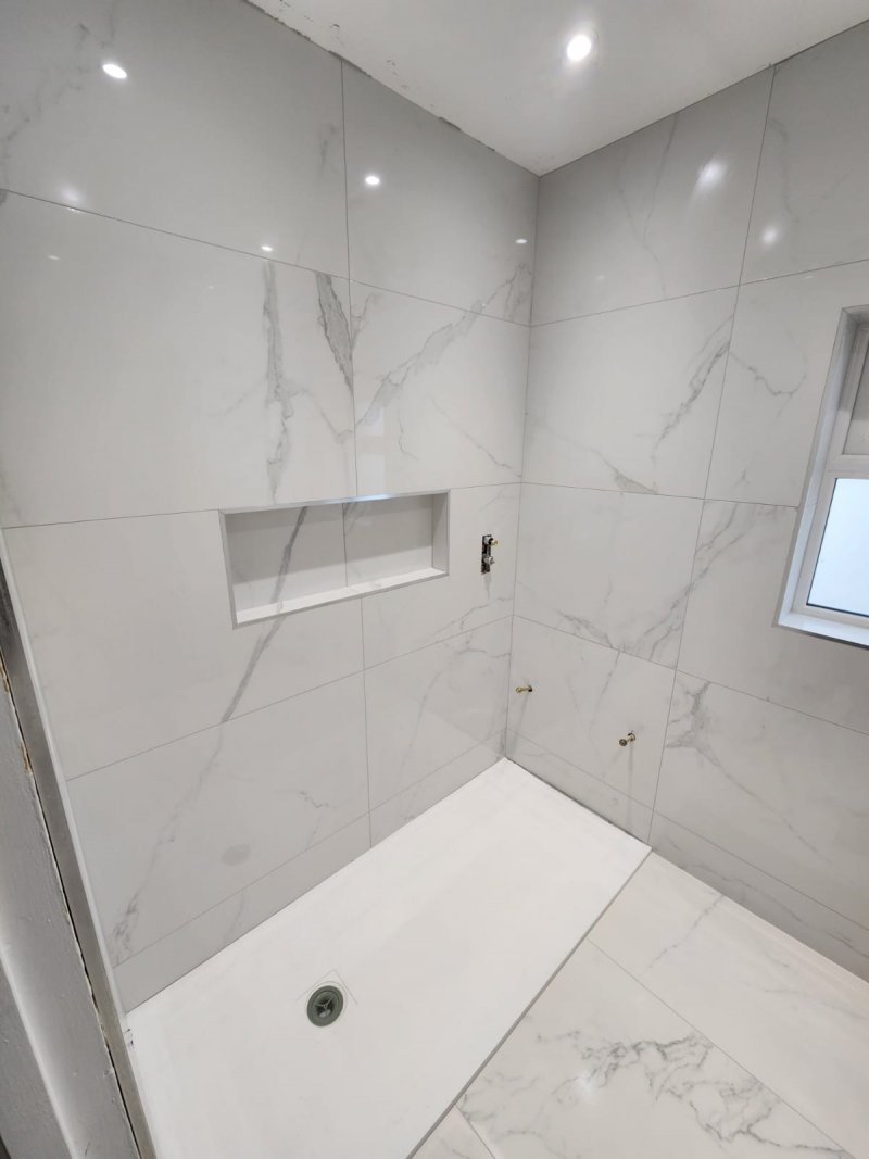 Diagonal view of bathroom with white marble and ceramic tile – RC Tiling Dublin