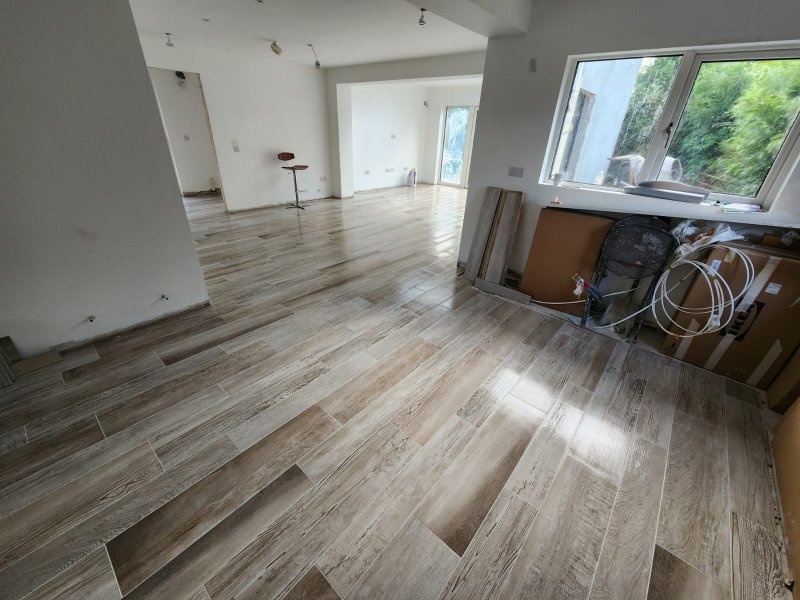 Seamless parquet flooring across open space leading into kitchen and adjacent room – RC Tiling Dublin