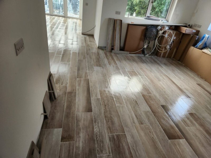 Sunlight reflecting on wood-effect porcelain flooring in open-plan interior
