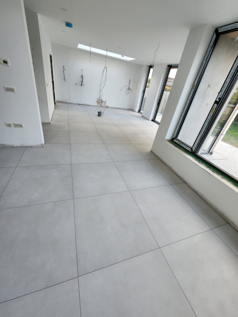 Wide view of sunlit room with large white tile flooring – RC Tiling Dublin