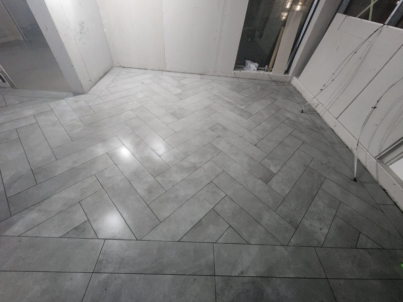 Stone tile flooring in herringbone pattern illuminated by natural light – RC Tiling Dublin  