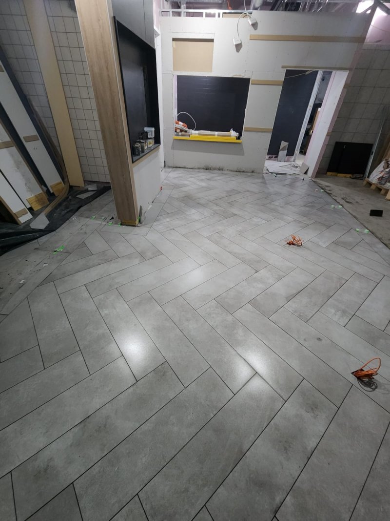 View from room entrance into hallway with herringbone stone tile flooring – RC Tiling Dublin  