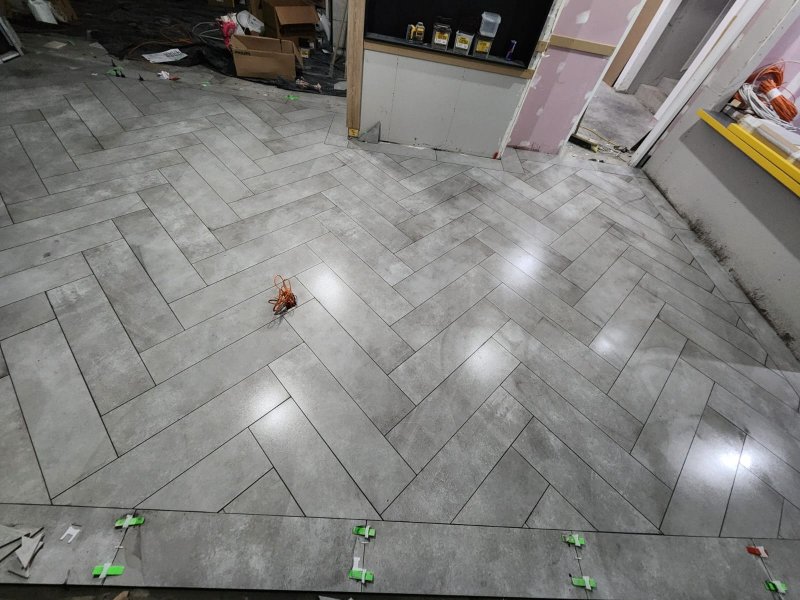 Diagonal view of herringbone stone tile flooring transitioning between rooms – RC Tiling Dublin  