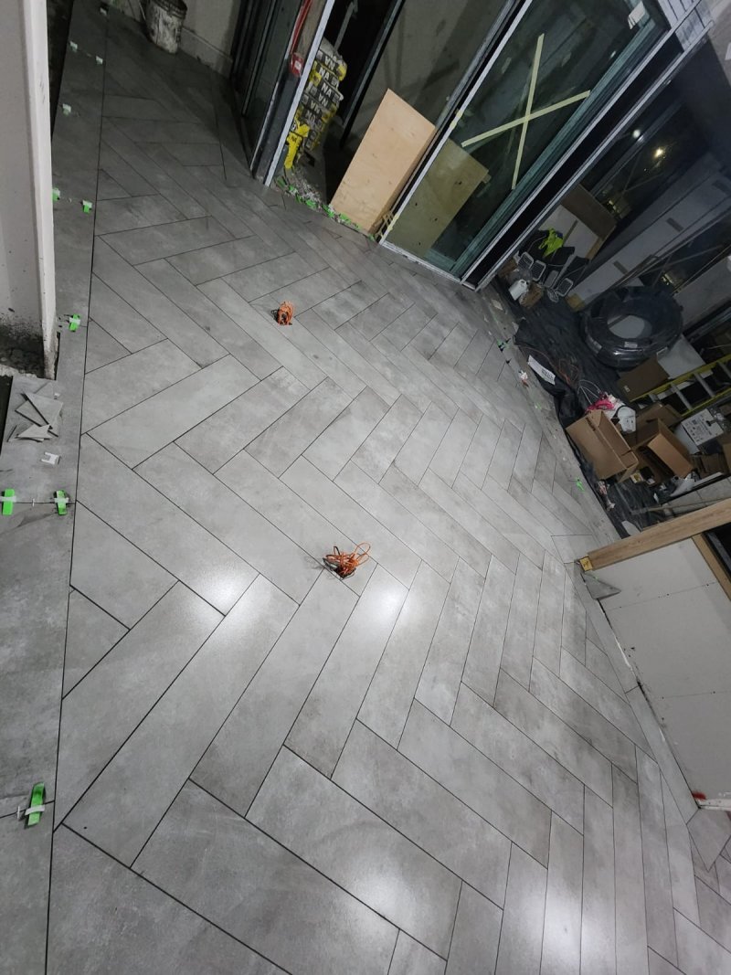 Elegance in Motion: Herringbone Stone-Effect Tiling