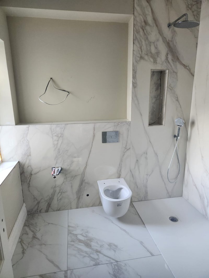 Rear view of marble bathroom with natural light and minimalist fixtures – RC Tiling Dublin