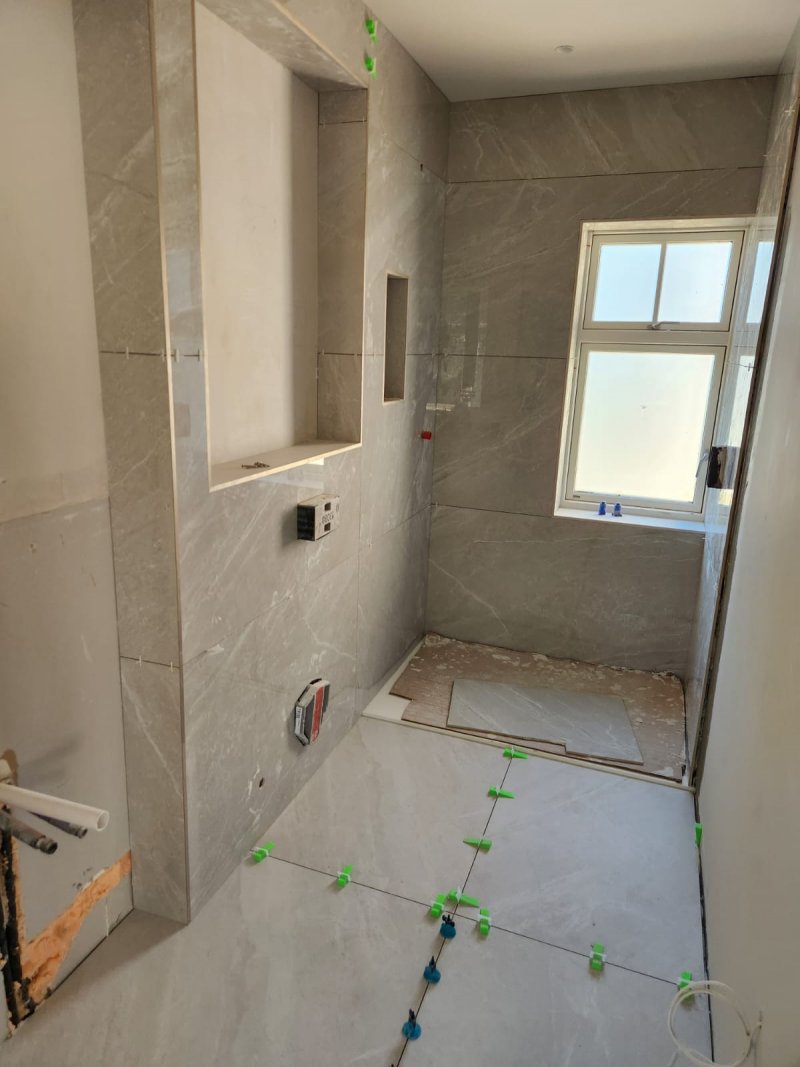 Bathroom under renovation with large ceramic tiles and recessed shower niche – RC Tiling Dublin