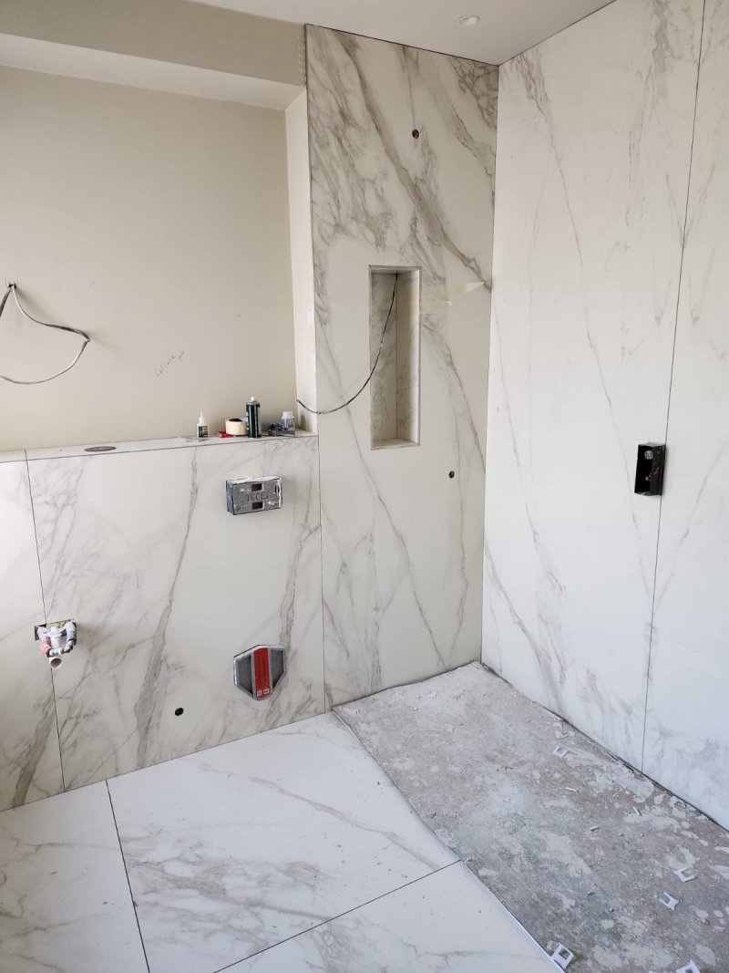 Bathroom floor with large white marble tiles and grey veining, no fixtures – RC Tiling Dublin