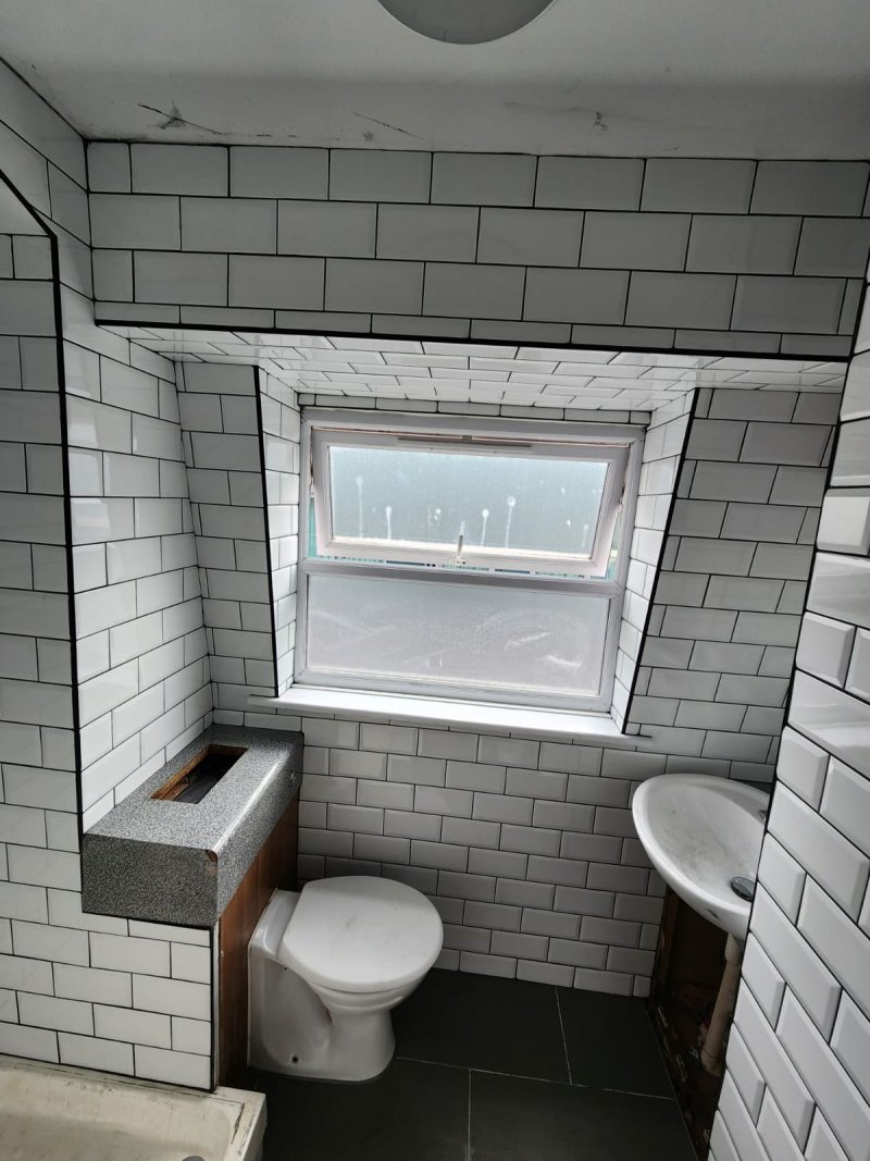 Bathroom view from door showing sink, toilet, and white ceramic tiles – RC Tiling Dublin