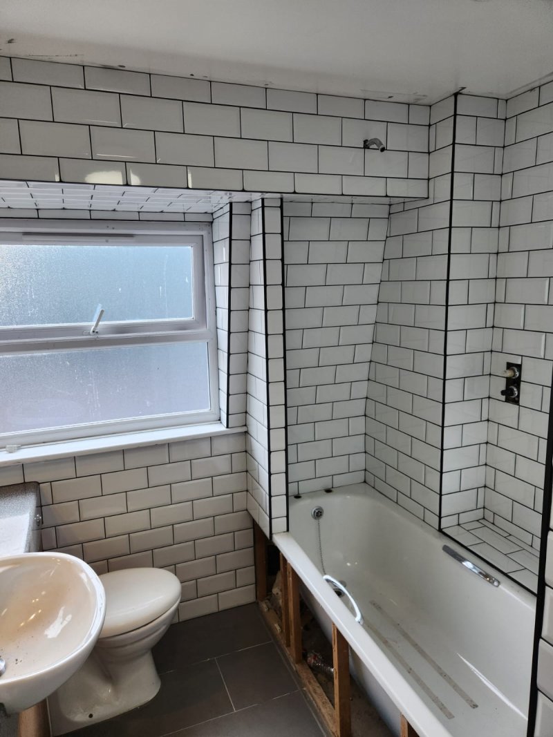 Bathroom with sink, toilet, bathtub, and white ceramic tiles in brick pattern – RC Tiling Dublin