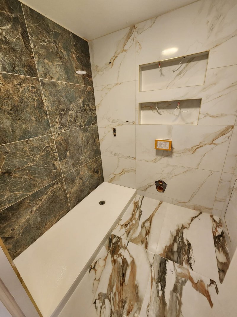 Diagonal view of shower corner with green and white marble tile transitions – RC Tiling Dublin