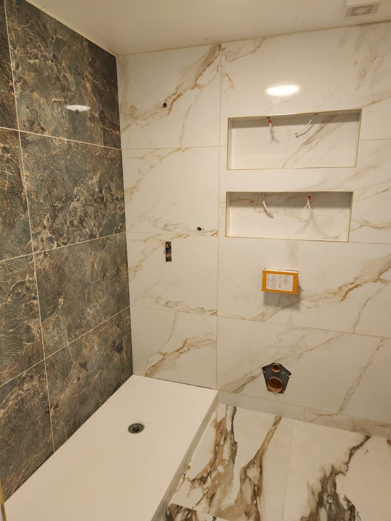 Side view of bathroom with white marble tiles featuring green and gold veining – RC Tiling Dublin