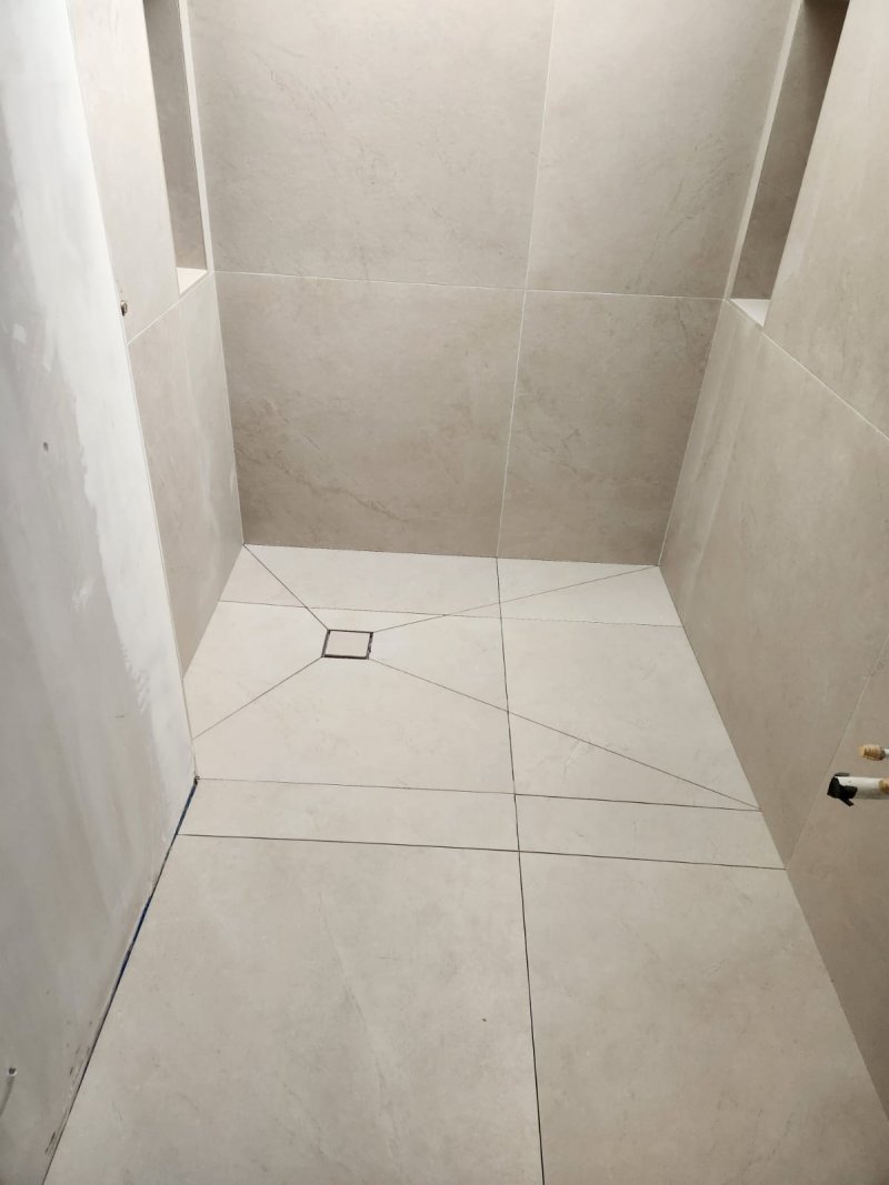 Modern bathroom with marble-look tiles, walk-in shower, wall-mounted toilet, and wooden vanity – RC Tiling Dublin