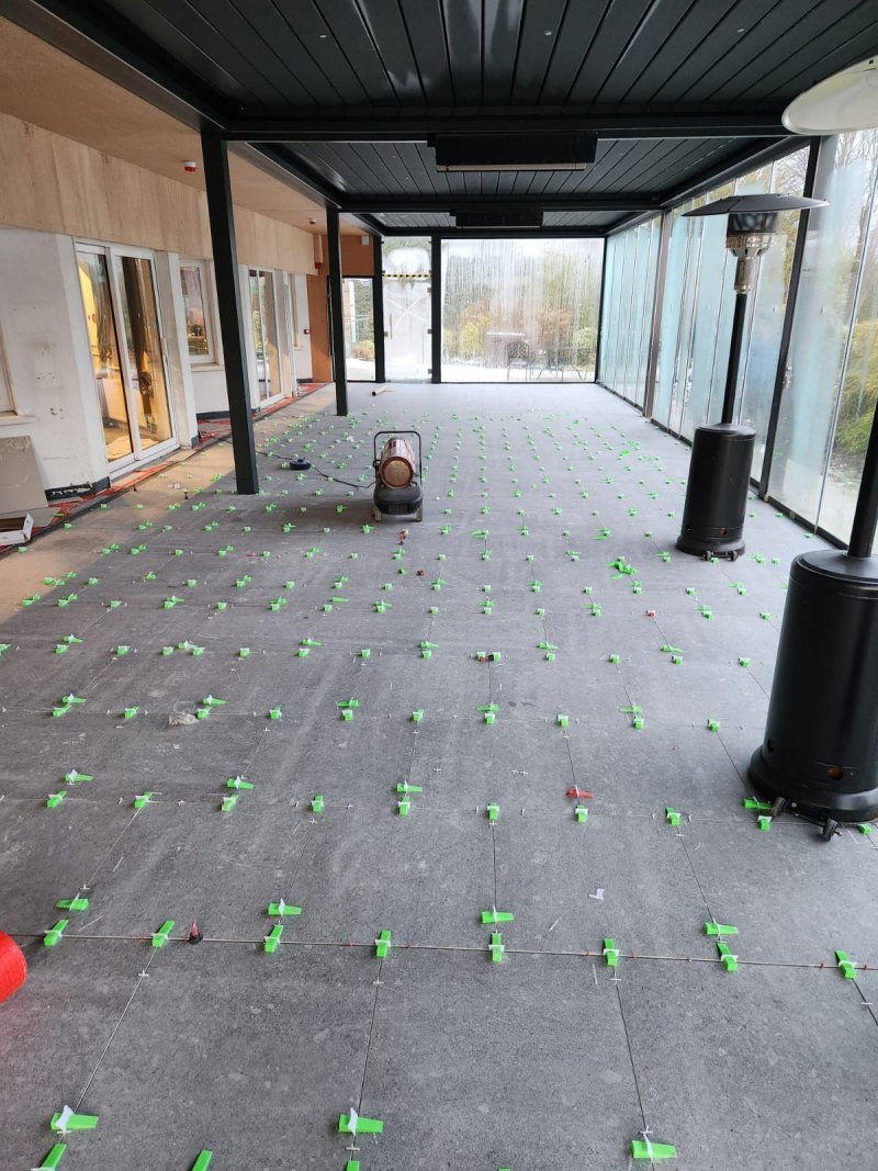 Outdoor living area with large ceramic tiles mid-installation – RC Tiling Dublin