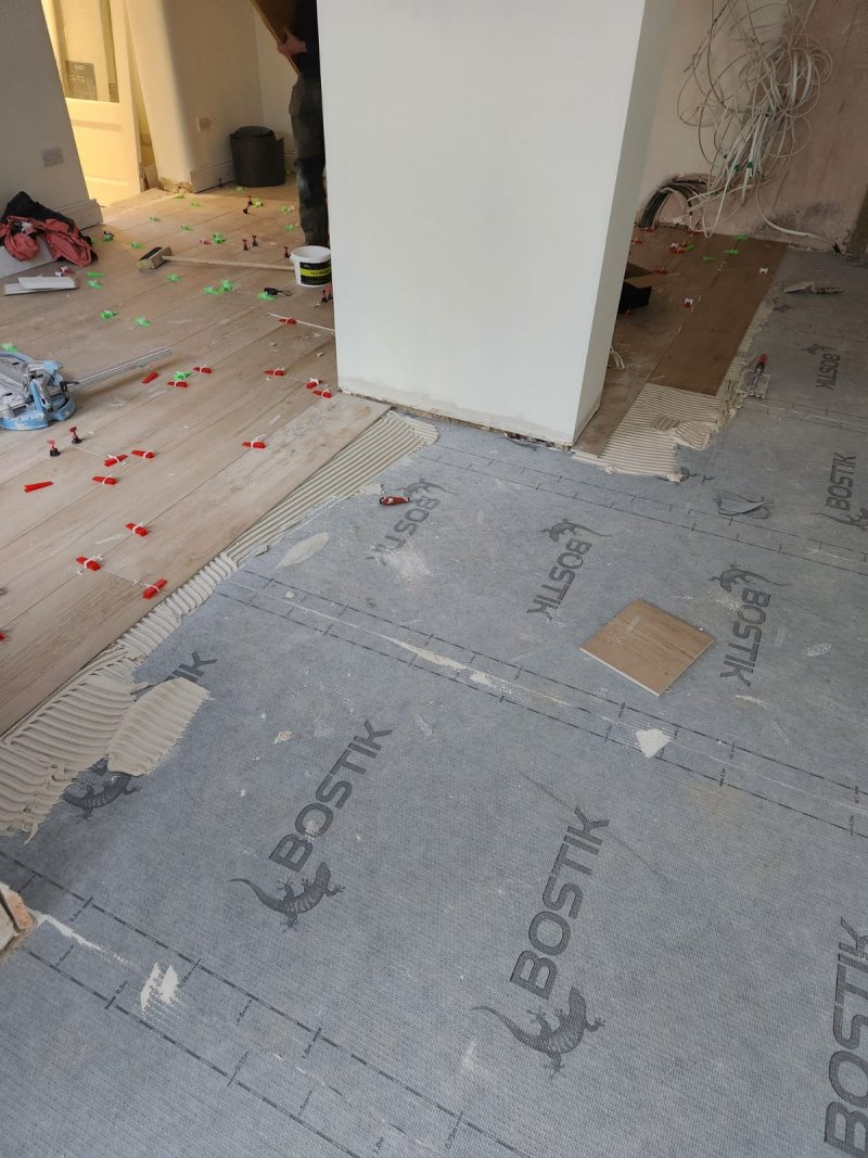 Tiling in progress with Bostik decoupling membrane and wood-effect porcelain tiles being laid by RCTiling Dublin.