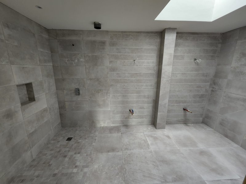 Bathroom with mosaic on curved shower wall and large-format tiles on floor and walls – RC Tiling Dublin