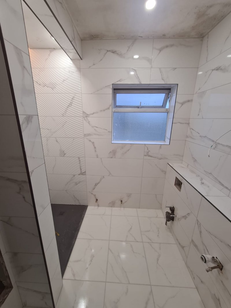 Bathroom with marble-effect large tiles and frosted window – RC Tiling Dublin