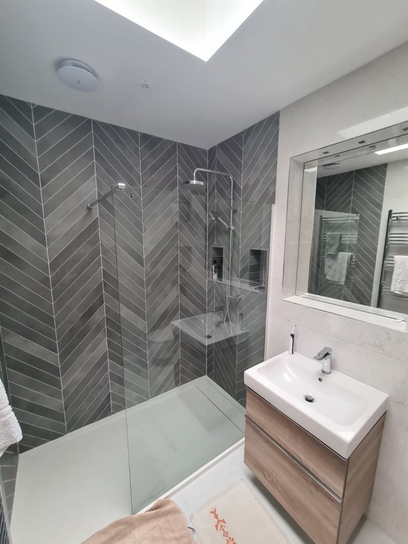 Close-up of chevron shower wall, vanity, and mirror in modern bathroom – RC Tiling Dublin