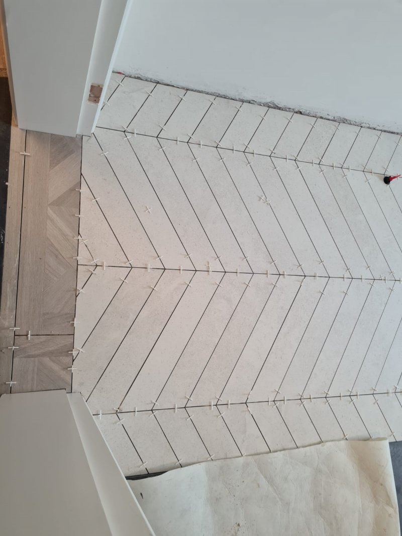 Chevron-pattern tile installation on bathroom floor with visible spacers – RC Tiling Dublin