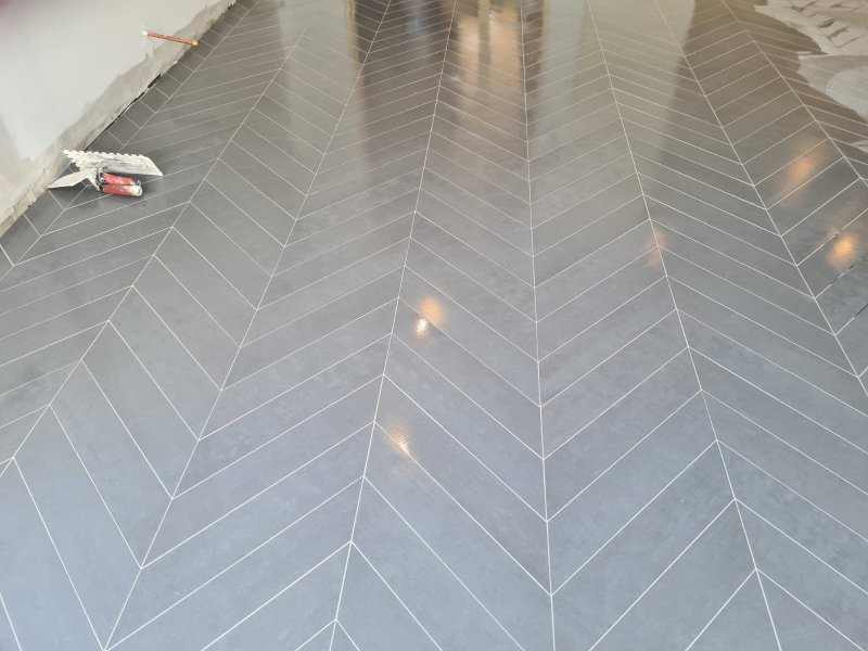 Finished chevron tile floor with glossy gray tiles and white grout – RC Tiling Dublin