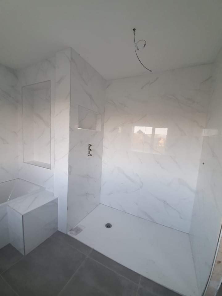 Shower area with marble-effect large tiles, built-in bench, and niche – RC Tiling Dublin