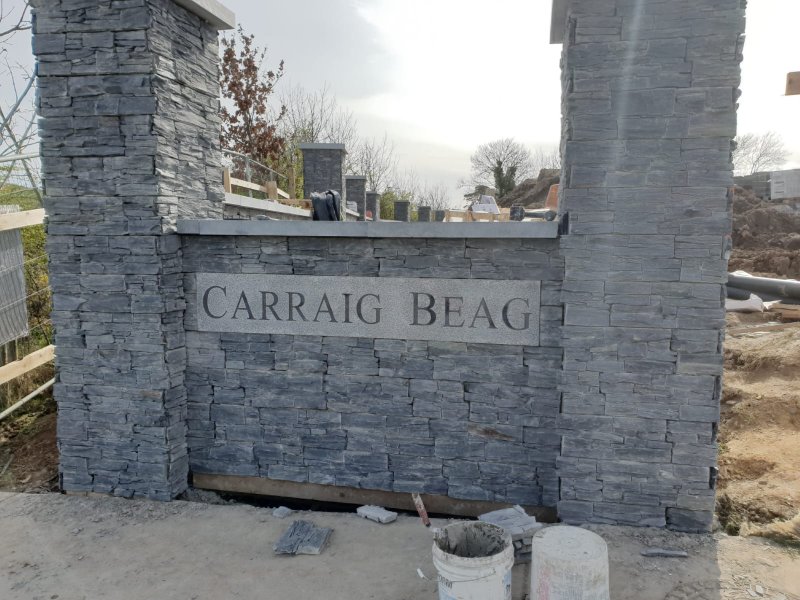 Stone entrance wall under construction with engraved Carraig Beag plaque – RC Tiling Dublin