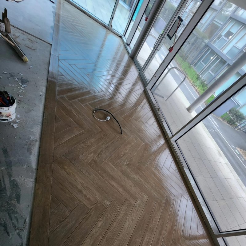 Entry area with finished herringbone parquet and beginning of ceramic tile installation – RC Tiling Dublin