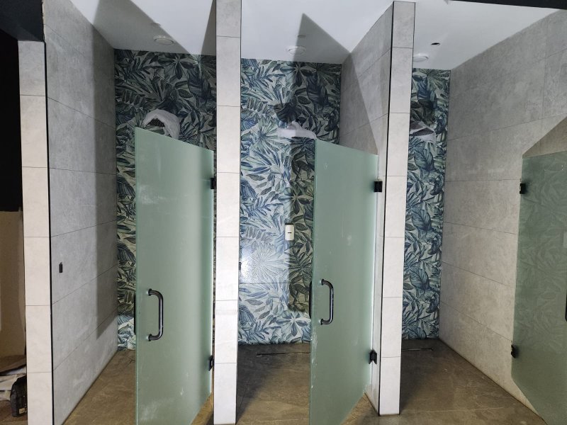 Frontal view of shower cabin with vertical green and white tile pattern – RC Tiling Dublin