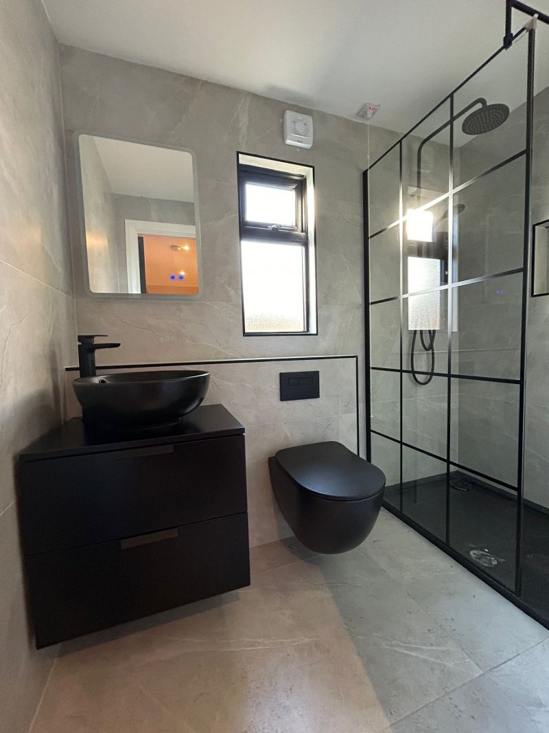Full bathroom renovation in Dublin featuring Crittall-style shower screen and grey porcelain tiling.