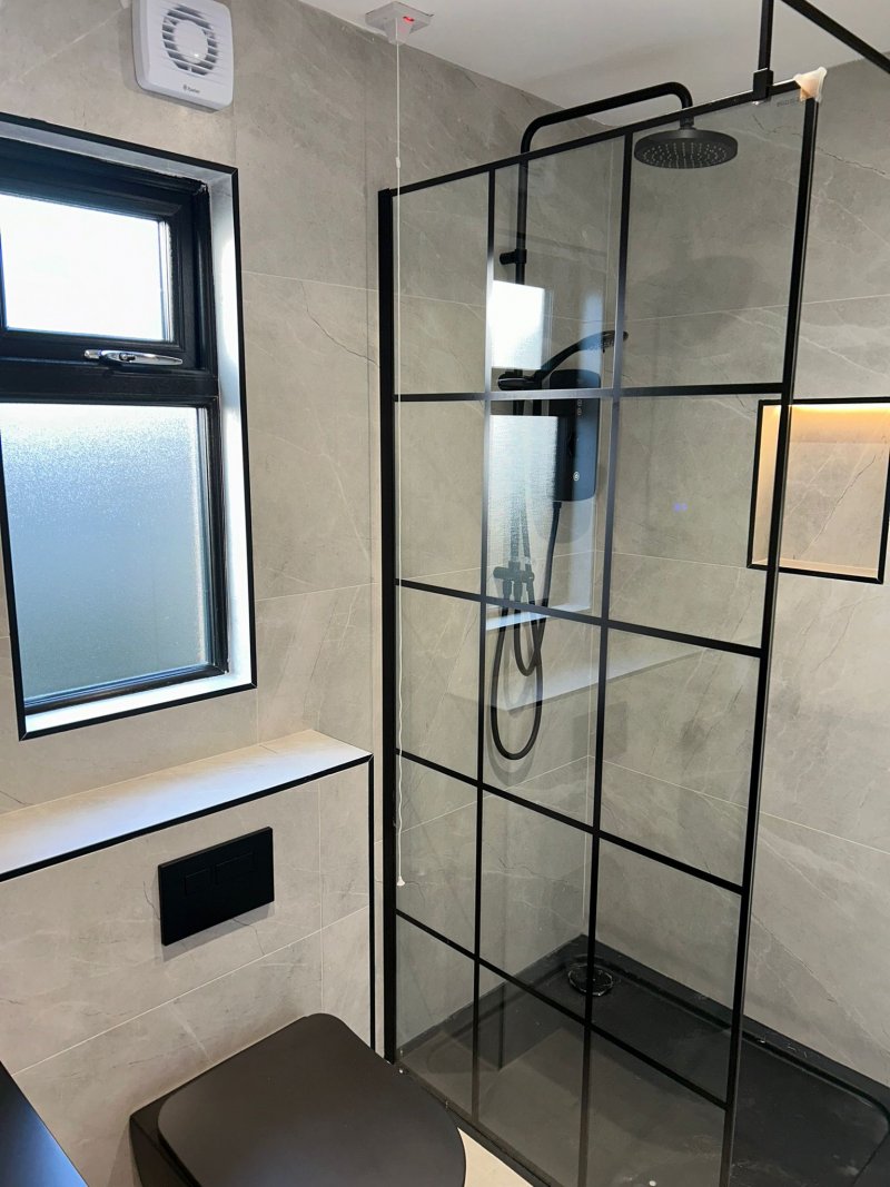 Minimalist bathroom with matte black vessel sink and rain shower by RC Tiling Dublin